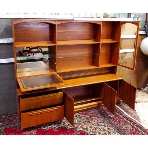 310 - Vintage / Retro: A Meredew two sectional teak sideboard, the top section having fitted shelves, a dr... 