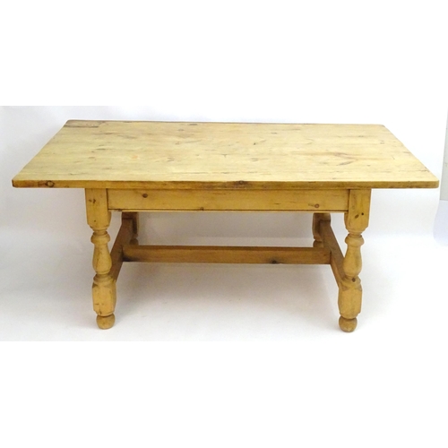 355 - A late 20thC pine kitchen table with a large rectangular top above a peg jointed base with four turn... 