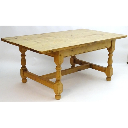 355 - A late 20thC pine kitchen table with a large rectangular top above a peg jointed base with four turn... 