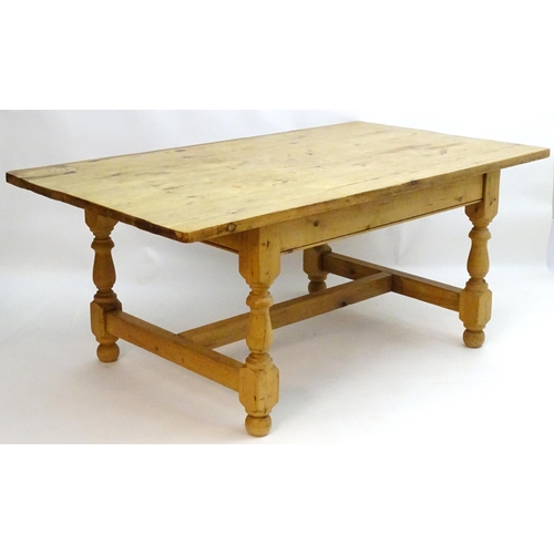 355 - A late 20thC pine kitchen table with a large rectangular top above a peg jointed base with four turn... 