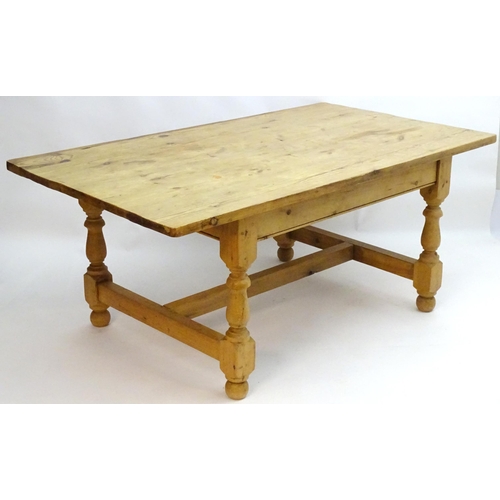 355 - A late 20thC pine kitchen table with a large rectangular top above a peg jointed base with four turn... 