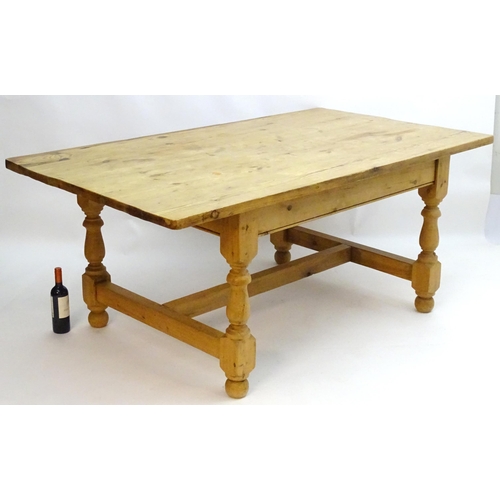 355 - A late 20thC pine kitchen table with a large rectangular top above a peg jointed base with four turn... 