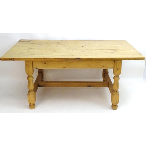 355 - A late 20thC pine kitchen table with a large rectangular top above a peg jointed base with four turn... 