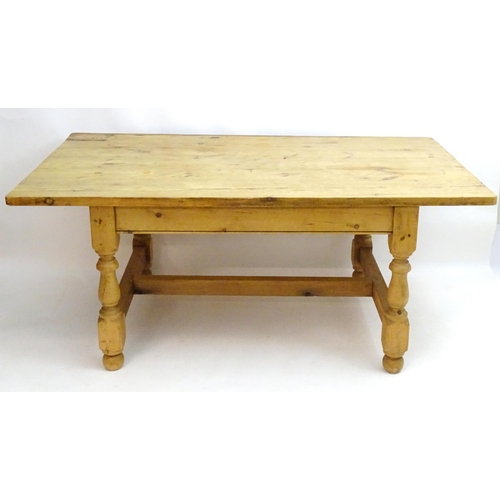 355 - A late 20thC pine kitchen table with a large rectangular top above a peg jointed base with four turn... 