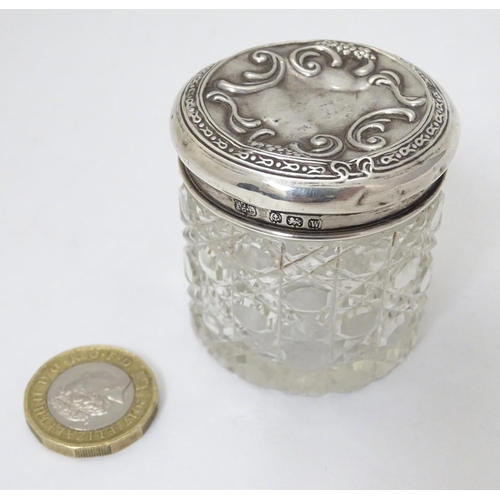 414 - A cut glass dressing table pot with silver top hallmarked Birmingham 1921 maker A J Pepper & Co. Ltd... 