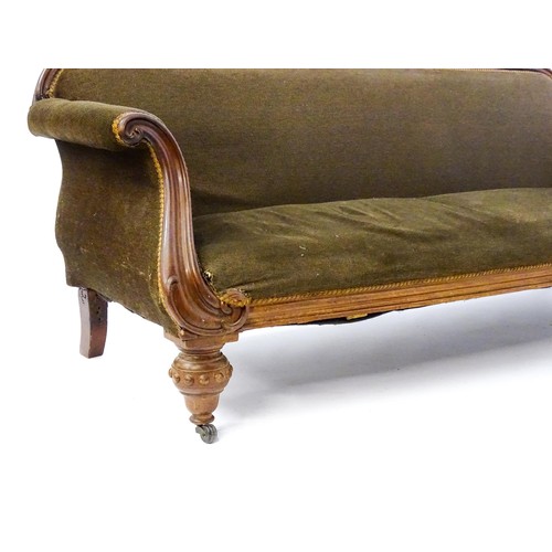 596 - A 19thC mahogany sofa with a moulded top rail above upholstered backrest and sprung seat, the scroll... 