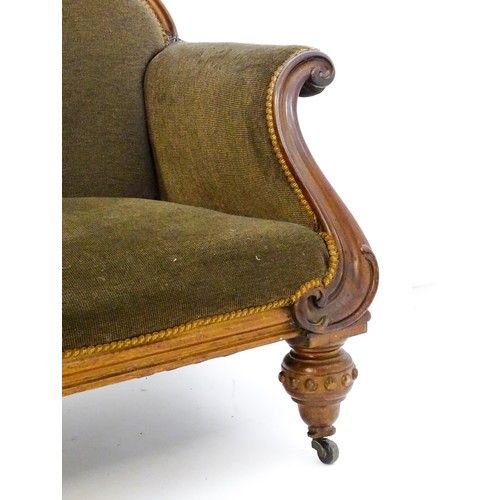 596 - A 19thC mahogany sofa with a moulded top rail above upholstered backrest and sprung seat, the scroll... 