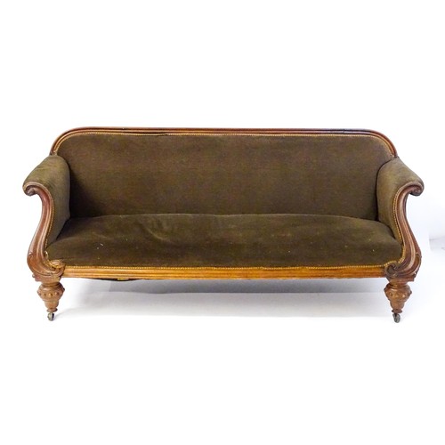 596 - A 19thC mahogany sofa with a moulded top rail above upholstered backrest and sprung seat, the scroll... 