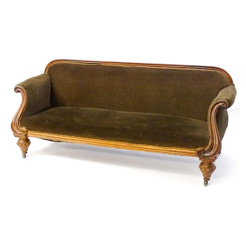 596 - A 19thC mahogany sofa with a moulded top rail above upholstered backrest and sprung seat, the scroll... 