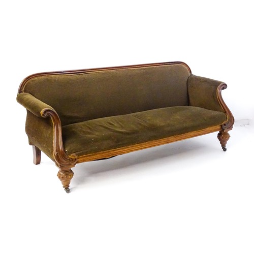 596 - A 19thC mahogany sofa with a moulded top rail above upholstered backrest and sprung seat, the scroll... 