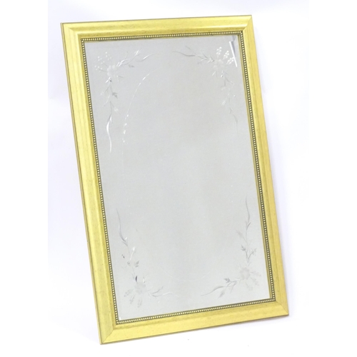 A bevelled cut glass mirror with etched floral decoration. Approx 29" x 41 1/2"