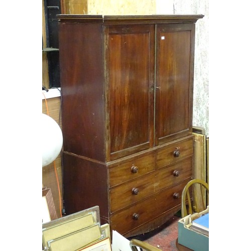 338 - An early 19thC mahogany linen press, having a moulded cornice above two panelled doors and the base ... 