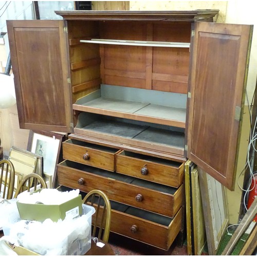 338 - An early 19thC mahogany linen press, having a moulded cornice above two panelled doors and the base ... 