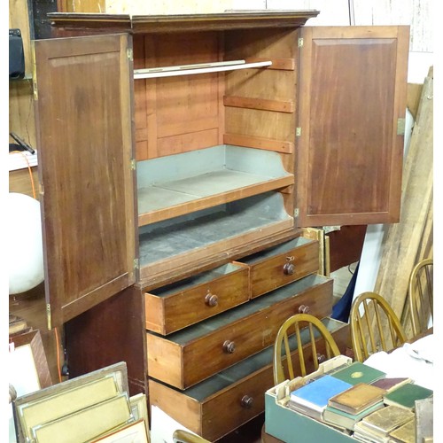 338 - An early 19thC mahogany linen press, having a moulded cornice above two panelled doors and the base ... 