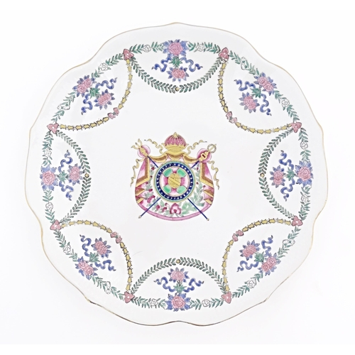 27 - A Chinese style armorial plate with crest to centre and swag / garland detail to border. Approx. 9
