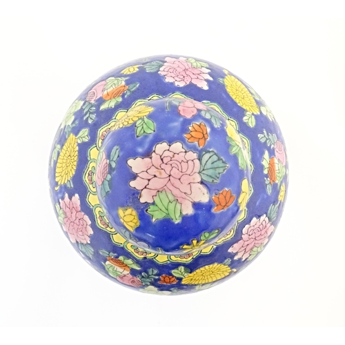 38 - A Chinese ginger jar with a blue ground decorated with flowers and foliage. Approx. 10 1/4