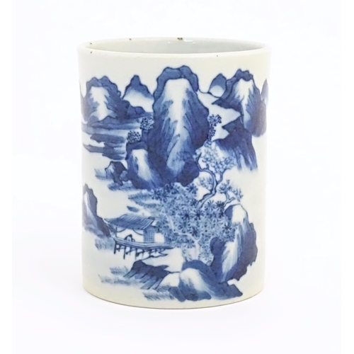 39 - A Chinese blue and white brush pot of cylindrical form decorated with a mountain landscape. Approx. ... 