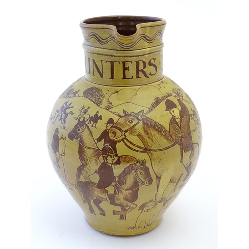 55 - A terracotta hunting jug decorated with a hunting scene, 'Made by Harry Juniper of Bideford'. Approx... 