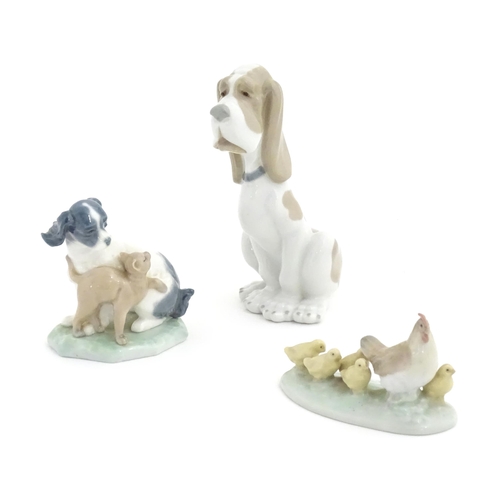 134 - Three Nao models of animals comprising a Basset Hound, a dog and cat 'In Harmony', and a chicken wit... 