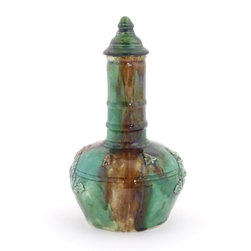 207 - A majolica bottle vase and cover with relief decoration depicting the snuff taker. Approx. 10