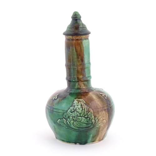 207 - A majolica bottle vase and cover with relief decoration depicting the snuff taker. Approx. 10