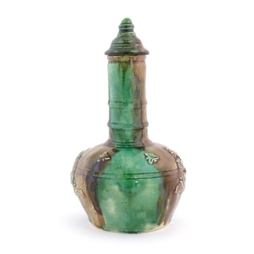 207 - A majolica bottle vase and cover with relief decoration depicting the snuff taker. Approx. 10