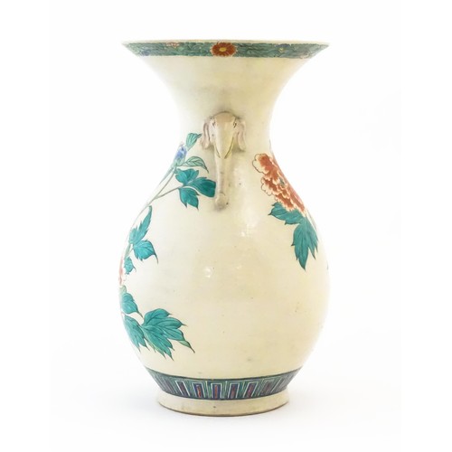 9 - An Oriental vase with twin elephant head handles, the body with hand painted floral and foliate deco... 