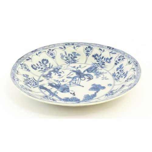 17 - A Chinese blue and white plate / dish decorated with two ladies in a garden landscape with a fence, ... 