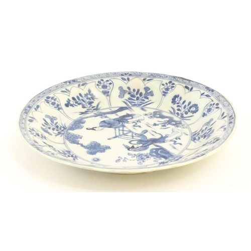 17 - A Chinese blue and white plate / dish decorated with two ladies in a garden landscape with a fence, ... 