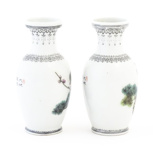 19 - A pair of Chinese vases each decorated with a crane bird perched in a pine tree with flowers. The ne... 