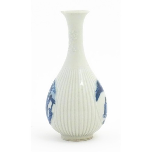 25 - A Chinese blue and white bottle vase with fluted detail decorated with scholar figures. Character ma... 