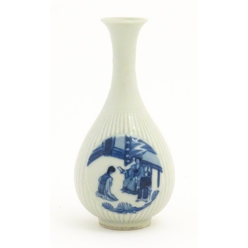 25 - A Chinese blue and white bottle vase with fluted detail decorated with scholar figures. Character ma... 