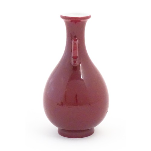 26 - A Chinese vase with shaped twin handles and a red / pink ground. Character marks under. Approx. 6 3/... 
