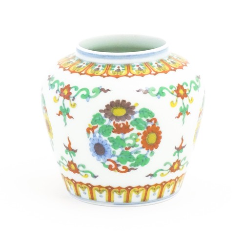 30 - A Chinese vase / jar decorated with roundels of flowers and foliage. Character marks under. Approx. ... 