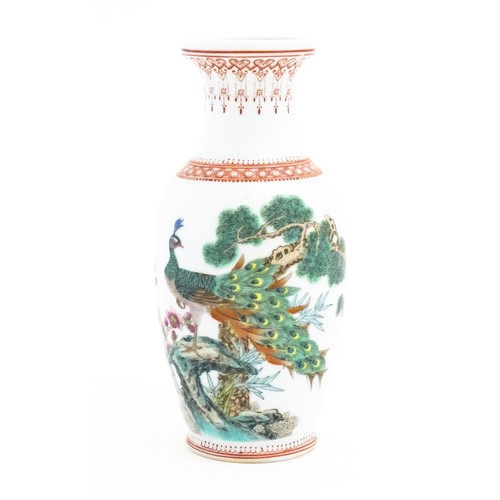 32 - A Chinese vase decorated with a peacock perched on a branch with flowers and foliage. Marked under. ... 