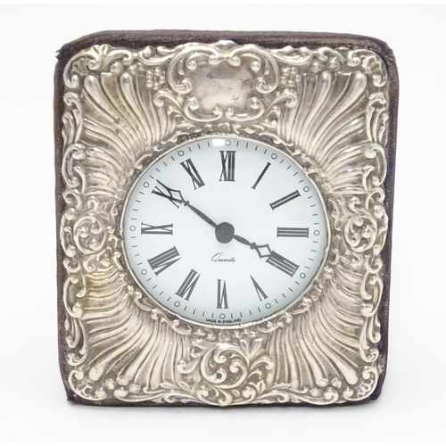 445 - An easel back clock with silver surround. Hallmarked London 1990 maker Keyford Frames Ltd. 4 1/2