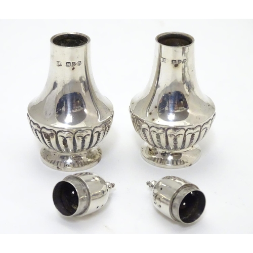 542 - A pair of silver pepperettes with fluted decoration. Hallmarked Chester 1900, maker Colen Hewer Ches... 