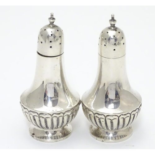 542 - A pair of silver pepperettes with fluted decoration. Hallmarked Chester 1900, maker Colen Hewer Ches... 