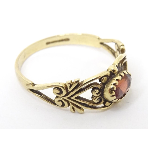 665 - A 9ct gold ring set with central garnet. Ring size approx M