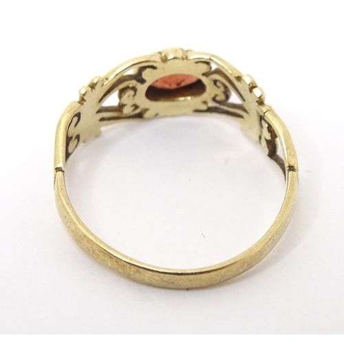 665 - A 9ct gold ring set with central garnet. Ring size approx M