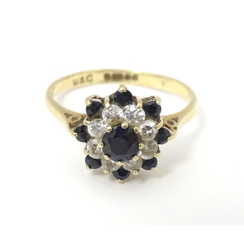 666 - A 9ct gold ring set with sapphires and white stones in a cluster setting. Ring size approx. M 1/2