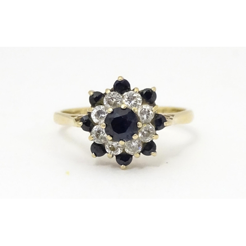 666 - A 9ct gold ring set with sapphires and white stones in a cluster setting. Ring size approx. M 1/2