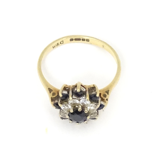 666 - A 9ct gold ring set with sapphires and white stones in a cluster setting. Ring size approx. M 1/2