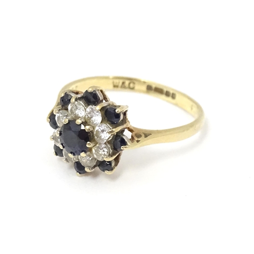 666 - A 9ct gold ring set with sapphires and white stones in a cluster setting. Ring size approx. M 1/2