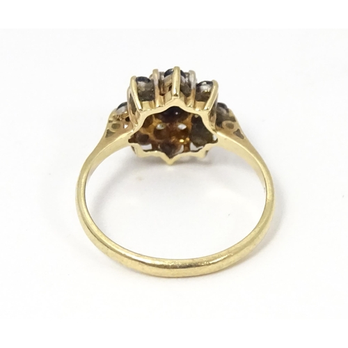 666 - A 9ct gold ring set with sapphires and white stones in a cluster setting. Ring size approx. M 1/2