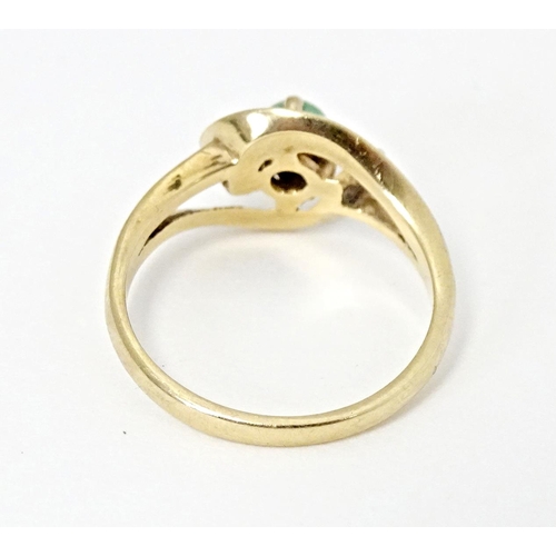 668 - A 9ct gold ring set with central green stone cabochon in an open setting. Ring size approx. O