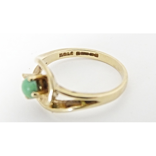 668 - A 9ct gold ring set with central green stone cabochon in an open setting. Ring size approx. O