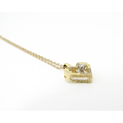 777 - A 9ct gold pendant of heart form set with central diamond, on a gold chain necklace approx 16