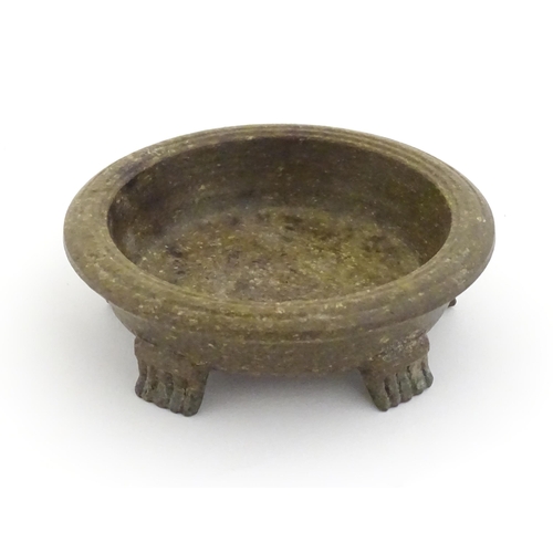 1128 - An Oriental stone dish with reeded rim and mica style decoration standing on five feet. Approx. 4