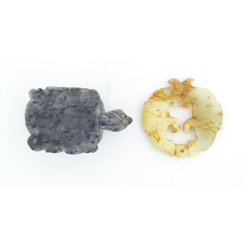 1135 - An Oriental carved hardstone pendant with stylised fish detail. Together with a soapstone carving mo... 